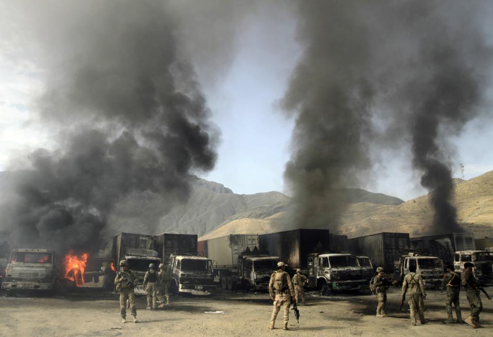 Nato troops and Afghan security forces arrive at the site of burning NATO supply trucks after an attack by militants in the Torkham area near the Pakistani-Afghan in Nangarhar Province June 19, 2014. (REUTERS/ Parwiz)