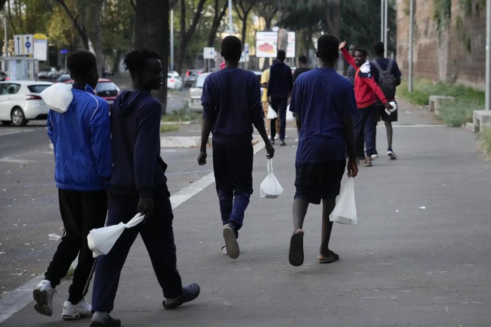 Migrants walk towards a station to board a bus directed to Marseille, France, in Rome, Tuesday, Sept. 12, 2023. Despite vows by Italy’s right-wing government to crack down on migrant arrivals and European Union-inked deals with Tunisia to stem the flow, the numbers of desperate people making the dangerous Mediterranean crossing keep rising. (AP Photo/Gregorio Borgia)