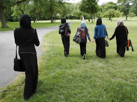 Yasmin (2nd L), 16, Hana (C), 16, and their friends walk in the park after finishing a GCSE exam near their school in Hackney, east London June 6, 2013. REUTERS/Olivia Harris/Files