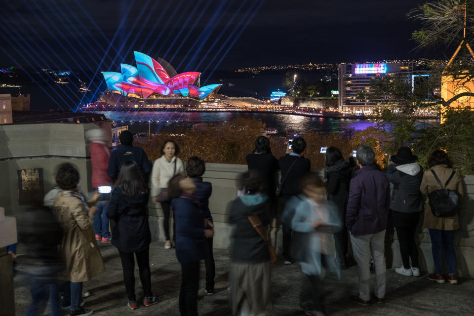 SYDNEY, AUSTRALIA - JUNE 06:  Tourists look over the city as the Sydney Opera House sails and surrounds are lit as part of the Vivid Festival on June 6, 2017 in Sydney, Australia. Vivid Sydney is an annual festival that features light sculptures and installations throughout the city. The festival takes place May 26 through June 17.  (Photo by Mark Kolbe/Getty Images)