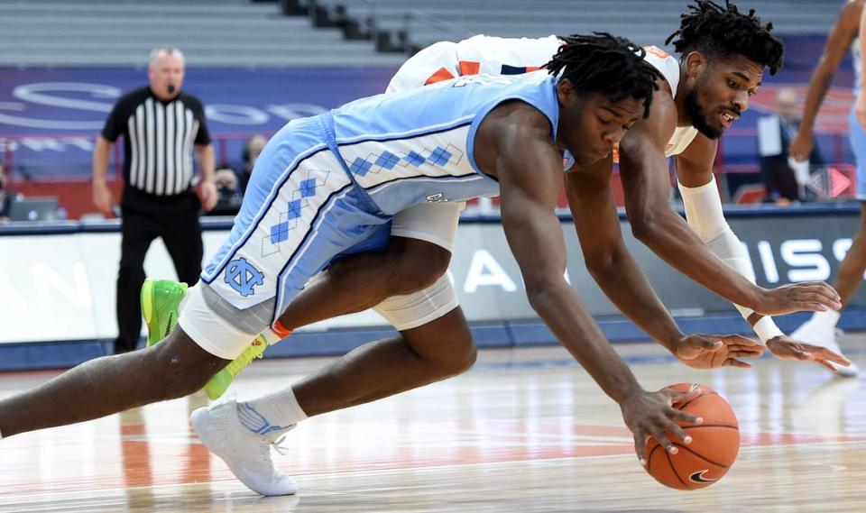 North Carolina Tar Heels forward Day’Ron Sharpe (11) and Syracuse Orange forward Quincy Guerrier (1) dive for a loose ball in a game between Syracuse and North Carolina at the Carrier Dome in Syracuse N.Y. March 1, 2021. Dennis Nett | dnett@syracuse.com