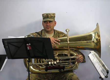 A U.S. soldier from NATO-led International Security Assistance Force (ISAF) holds his trumpet before the change of mission ceremony in Kabul, December 28, 2014. REUTERS/Omar Sobhani