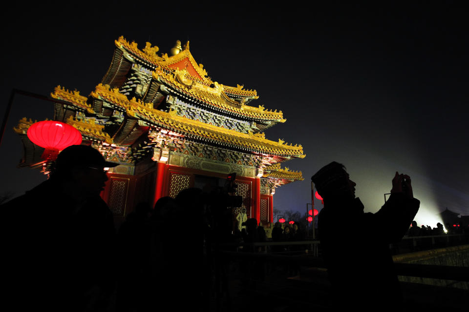 In this Tuesday, Feb. 19, 2019, photo, visitors is silhouetted as they tour the Forbidden City decorated with red lanterns and projected with lights for the Lantern Festival in Beijing. China lit up the Forbidden City on Tuesday night, marking the end of 15 days of lunar new year celebrations. It was not a Lantern Festival the last emperor, who abdicated in 1912, would have recognized. There were lanterns, but those lucky enough to snag tickets saw a laser light show and historic buildings bathed in colorful lights. Others watched from outside the vast walled compound in Beijing, from where Ming and Qing dynasty emperors ruled for five centuries. (AP Photo/Andy Wong)