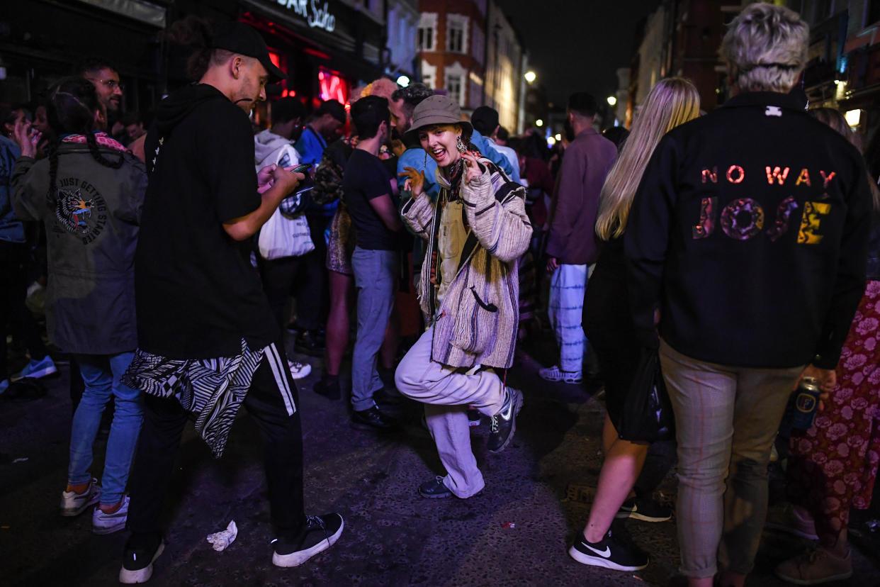 LONDON, ENGLAND - JULY 04: A woman is seen dancing outside a pub in Soho on July 4, 2020 in London, United Kingdom. The UK Government announced that Pubs, Hotels and Restaurants can open from Saturday, July 4th providing they follow guidelines on social distancing and sanitising. (Photo by Peter Summers/Getty Images)