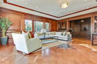 <p>This great room also boasts a bar and wood decor. (Sotheby’s International Realty) </p>