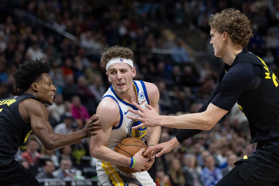 Golden State Warriors guard Brandin Podziemski (2) is blocked by Utah Jazz forward Lauri Markkanen (23) and Utah Jazz guard Collin Sexton (2) during a game at the Delta Center in Salt Lake City on Monday, Feb. 12, 2024.