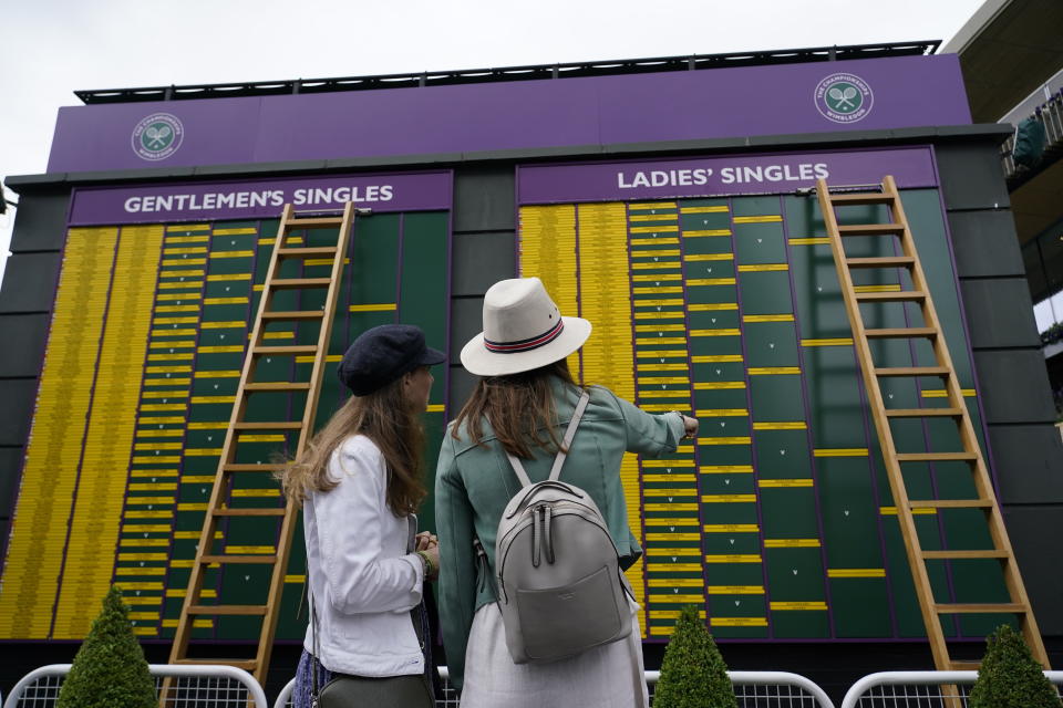 FILE - Spectators look at the order of play on day eight of the Wimbledon Tennis Championships in London, Tuesday, July 6, 2021. This year's Wimbledon tournament begins on Monday, July 1.(AP Photo/Alberto Pezzali, File)