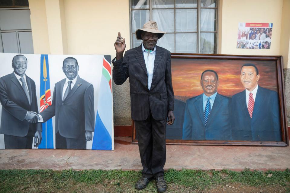 <p>A village elder poses for a photographer in front of a paiting featuring former US president Barack Obama and Kenyan opposition leader Raila Odinga (R), prior to an opening ceremony of the Sauti Kuu Sports, Vocational and Training Centre in his ancestral home Kogelo, some 400km west of the capital Nairobi, Kenya on July 16, 2018. (Photo: Dai Kurokawa/EPA-EFE/REX/Shutterstock) </p>