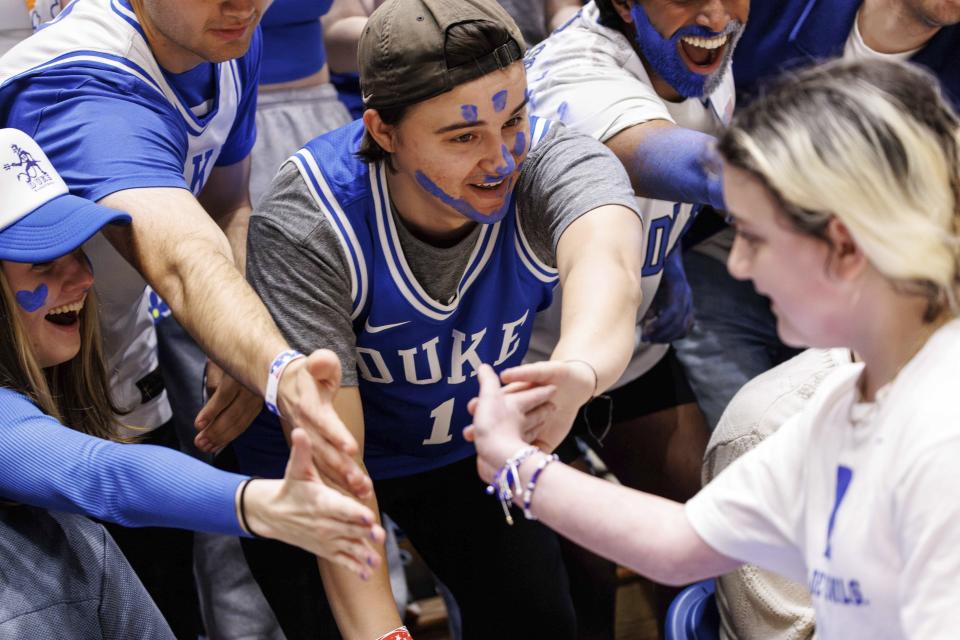 Samantha DiMartino, right, greets fans in the Duke student section after being honored as a part of the Scheyer Family Kid Captains Program, which recognizes patients and families of Duke Children's Hospital, during an NCAA college basketball game between Duke and Louisville in Durham, N.C., Wednesday, Feb. 28, 2024. (AP Photo/Ben McKeown)