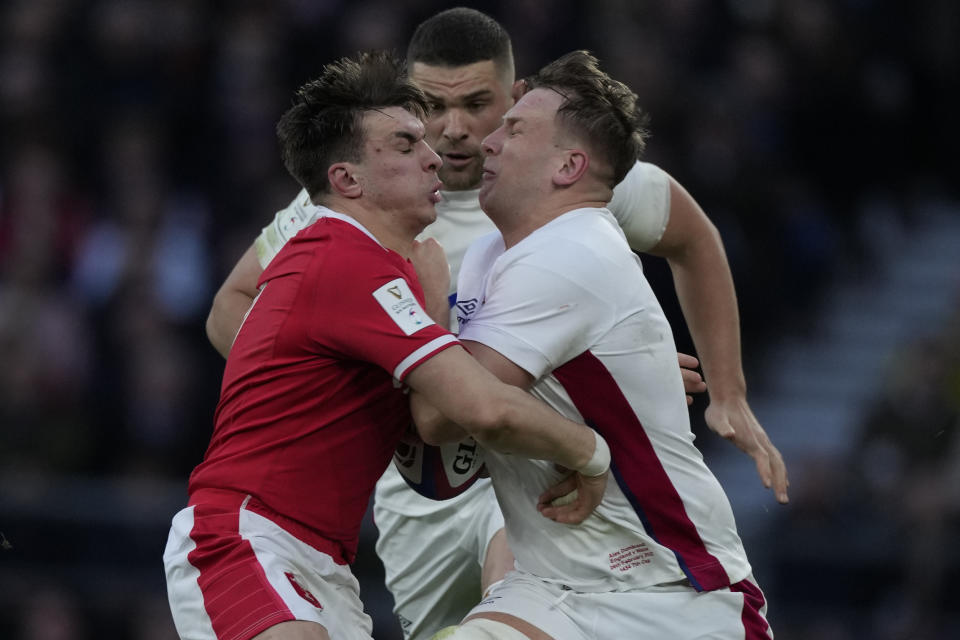 FILE - Wales' Taine Basham, left, and England's Alex Dombrandt vie for the ball during the Six Nations rugby union match between England and Wales at Twickenham stadium, London, on Feb. 26, 2022. The Rugby World Cup will take place to the backdrop of a concussion lawsuit that has similarities to one settled by the NFL in 2013 at a likely cost of more than $1 billion. (AP Photo/Alastair Grant, File)