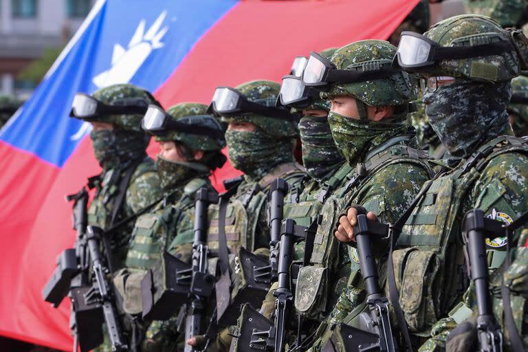 Soldados con la bandera de Taiwán después de un ejercicio de mejoramiento de preparación de defensa contra intrusiones militares de China en Kaohsiung, Taiwán. (AP Foto/Daniel Ceng)