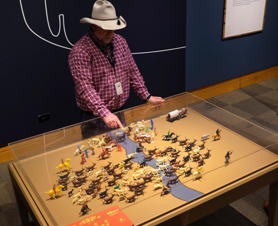 Michael Grauer, McCasland Chair of Cowboy Culture and Curator of Cowboy Collections and Western Art at the National Cowboy & Western Heritage Museum, shows off a cattle drive play set to members of the media about the exhibit "Playing Cowboy" Friday, March 24, 2023, in Oklahoma City. "Playing Cowboy" features Western books, games and toys for children.