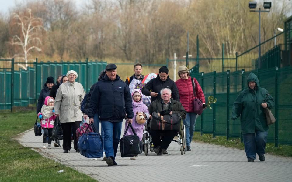  Refugees walk after fleeing the war from neighbouring Ukraine at the border crossing in Medyka, southeastern Poland - Sergei Grits/ AP