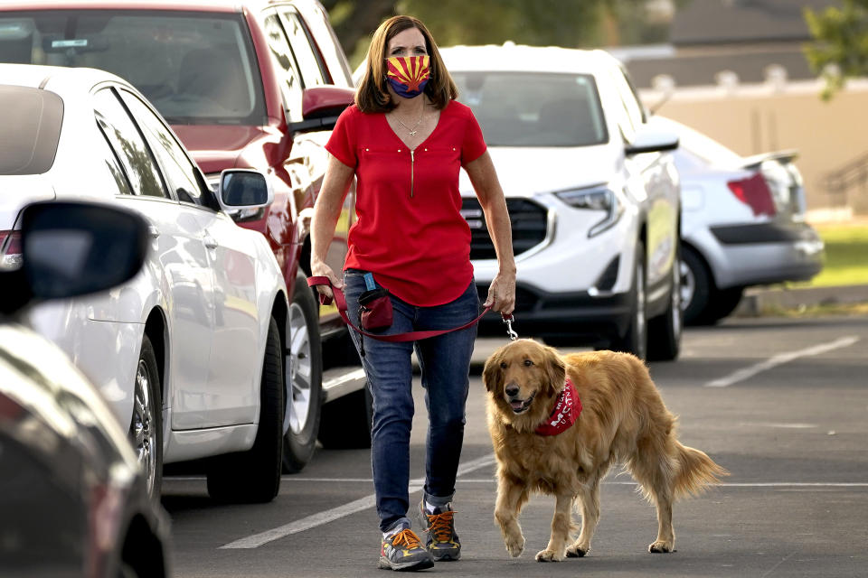 U.S. Sen. Martha McSally, R-Ariz., walks her dog Boomer to greet voters at a polling station early, Tuesday, Nov. 3, 2020, in Mesa, Ariz. (AP Photo/Matt York)