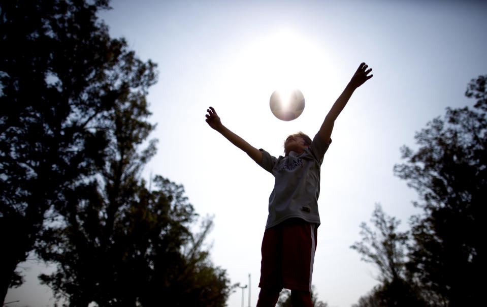 In this Sept. 8, 2018 photo, Candelaria Cabrera plays with a soccer ball in Chabas, Argentina. "Cande," as she is known by friends and family, is the only girl playing in a children's soccer league in the southern part of Argentina's Santa Fe province, birthplace of stars including Lionel Messi, Gabriel Batistuta and Jorge Valdano. (AP Photo/Natacha Pisarenko)