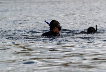 Divers look for people believed to be missing after a tourist boat sank on Sunday in the Penol-Guatape reservoir, in Guatape, Colombia June 26, 2017. REUTERS/Fredy Builes