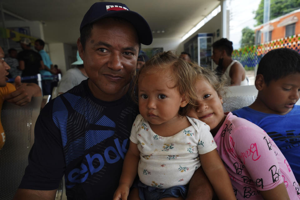 Nicaraguan migrant Jose Soliz Elias sits with his daughters at the bus terminal after receiving documents that allow them to legally travel through Mexico, in Huixtla, Chiapas state, Mexico, Friday, June 10, 2022. Thousands of migrants left Tapachula by foot at the start of the week, tired of waiting for normalize their status in a region with little work, with the ultimate goal of reaching the U.S. (AP Photo/Marco Ugarte)