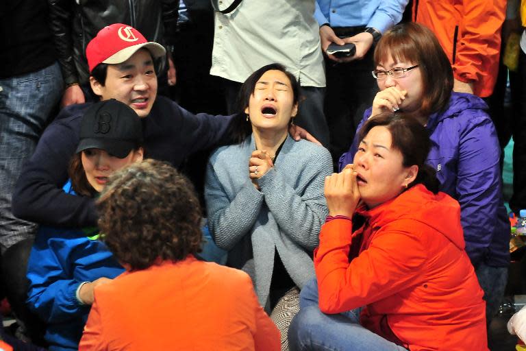 South Korean relatives of passengers on board a capsized ferry cry as they wait for news about their loved ones, at a gym in Jindo on April 17, 2014