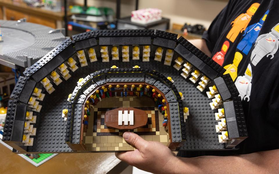 Scott Brown holds a Lego version of the Pro Football Hall of Fame gallery that houses the bronze busts of the Hall of Famers. Brown built a Lego version of the Hall of Fame without any plan, simply from his creation.