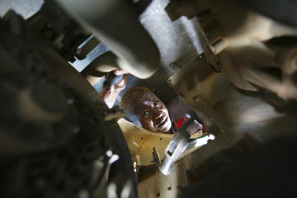 Memory Mukabeta repairs a car at her workshop in Harare, in this Friday, March,5, 2021 photo. Mukabeta runs a car repair shop, a vocation traditionally viewed as a male domain. Mukabeta supports members of her extended family whose livelihoods have been hit by the restrictions caused by the virus. From driving trucks and fixing cars to encouraging girls living with disability to find their places in society, women in Zimbabwe are refusing to be defined by their gender or circumstances, even as the pandemic hits them hardest hardest and imposes extra burdens. (AP Photo/Tsvangirayi Mukwazhi)