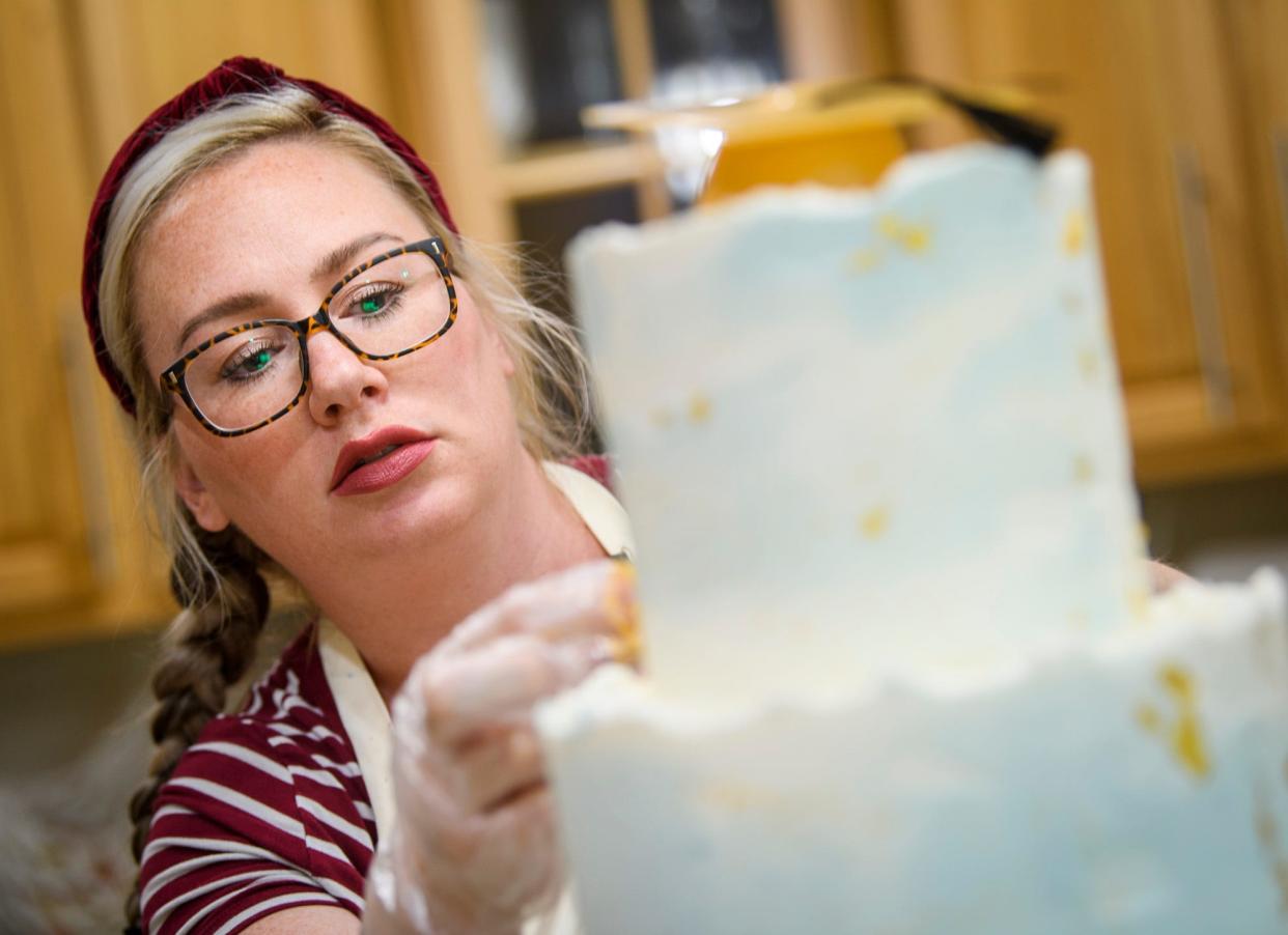 Changes are coming to Indiana's cottage food laws. Bakers like Allison Ballman will be allowed to deliver cakes and other homemade products to clients. Here Ballman decorates a cake she made in her home on Friday, June 10, 2022.