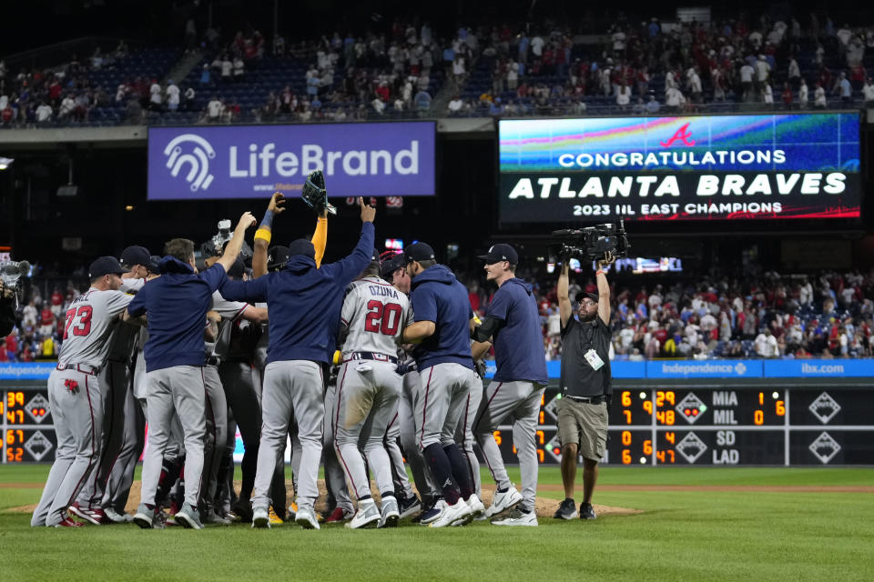 Atlanta Braves players and coaches celebrate after clinching their sixth consecutive NL East title by defeating the Philadelphia Phillies in a baseball game, Wednesday, Sept. 13, 2023, in Philadelphia. (AP Photo/Matt Slocum)