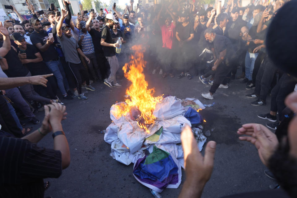 Supporters of Shiite Muslim leader Moqtada Sadr burn a rainbow flag, during a demonstration in front of the Swedish embassy in Baghdad in response to the burning of Quran in Sweden, Baghdad, Iraq, Friday, June 30, 2023. (AP Photo/Hadi Mizban)