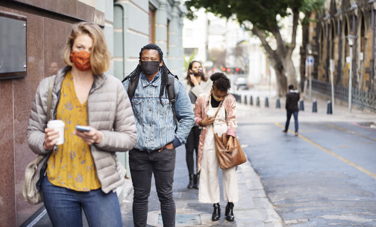 People standing in line and wearing masks.