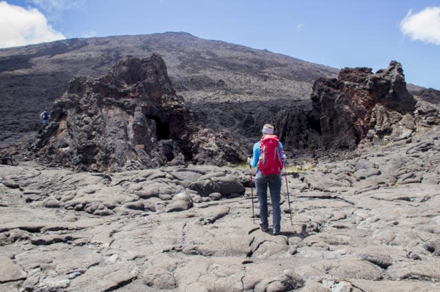 Hiker arriving at La Chapelle de Rosemont on the volcano Piton de La Fournaise, Reunion island