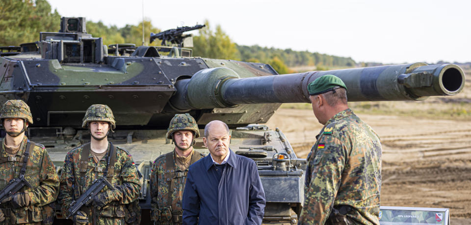 FILE - German Chancellor Olaf Scholz talks to German army Bundeswehr soldiers at a "Leopard 2" main battle tank during a training and instruction exercise in in Ostenholz, Germany, Monday, Oct. 17, 2022. Germany has become one of Ukraine's leading weapons suppliers in the 11 months since Russia's invasion. The debate among allies about the merits of sending battle tanks to Ukraine has focused the spotlight relentlessly on Germany, whose Leopard 2 tank is used by many other countries and has long been sought by Kyiv. (Moritz Frankenberg/dpa via AP, File)