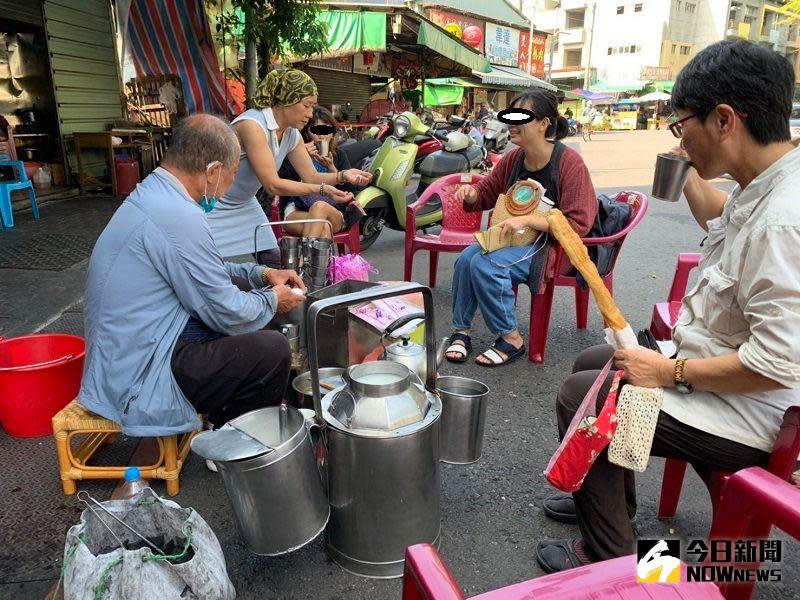 ▲80年歷史的「炭燒杏仁茶尬油條」，就在南門圓環邊人車熙來攘往的馬路旁，饕客們都倚坐在攤位前甘冒危險，悠然享受全台限定的古早美味。(圖／記者陳惲朋攝）