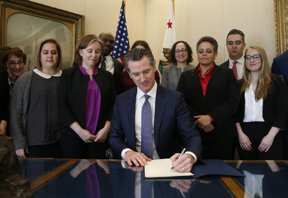 Gov. Gavin Newsom signs the executive order placing a moratorium on the death penalty at his Capitol office Wednesday, March 13, 2019, in Sacramento, Calif. (AP Photo/Rich Pedroncelli)