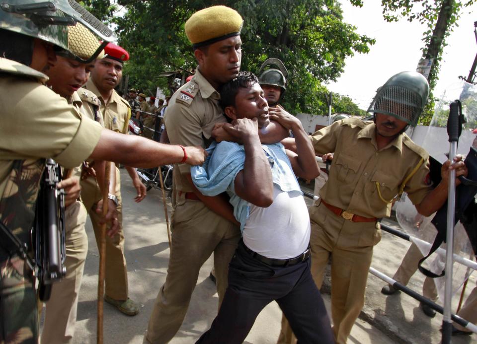 Police detain a demonstrator during a protest in front of the secretariat building in Guwahati city