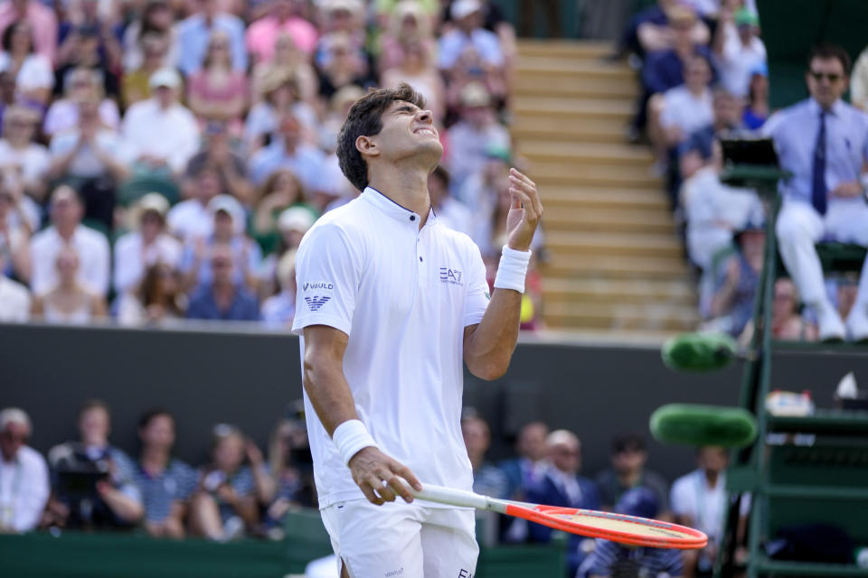 Chile's Cristian Garin celebrates after defeating Australia's Alex De Minaur during a men's singles fourth round match on day eight of the Wimbledon tennis championships in London, Monday, July 4, 2022. (AP Photo/Kirsty Wigglesworth)