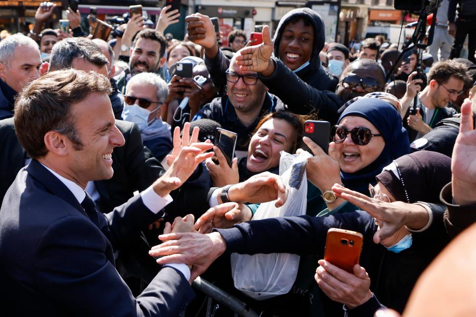 Macron greets a crowd in Saint Denis (AP)