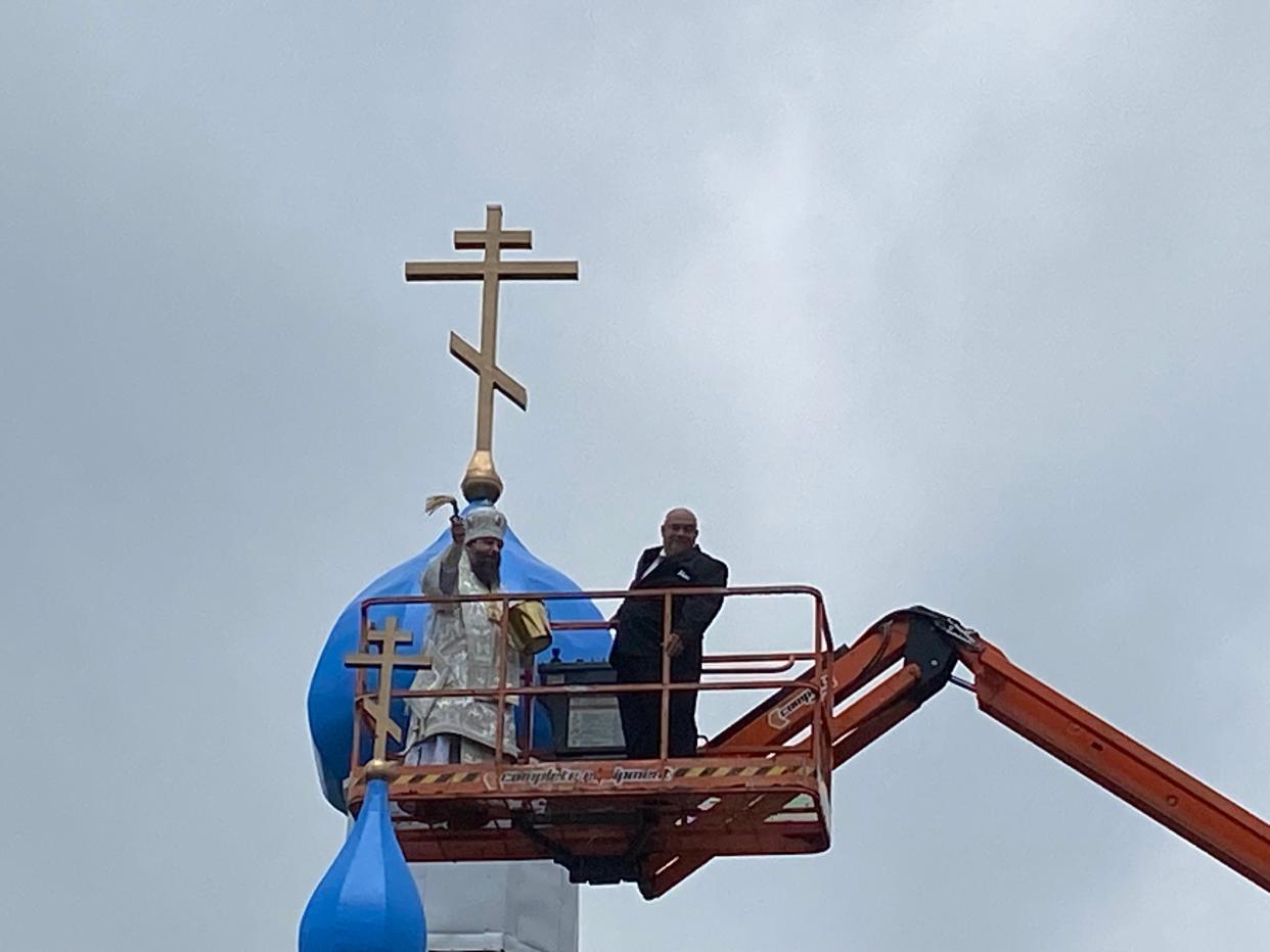 Metropolitan Nicholas Olhovsky gets a lift from roofer J.R. August to bless the St. George's Church, its new roof and the congregation in Howell on St. George's Day, May 7, 2024.