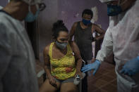 Mobile Emergency Care Service (SAMU) worker Elias Anjo, right, checks a patient suspected of having COVID-19 at her house in Duque de Caxias, Rio de Janeiro state, Brazil, Tuesday, April 6, 2021. (AP Photo/Felipe Dana)