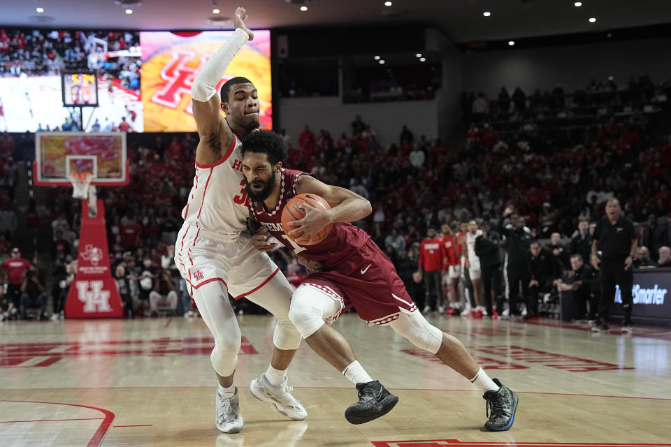 Temple's Damian Dunn (1) drives to the basket as Houston's Reggie Chaney (32) defends during the second half of an NCAA college basketball game Sunday, Jan. 22, 2023, in Houston. Temple won 56-55. (AP Photo/David J. Phillip)