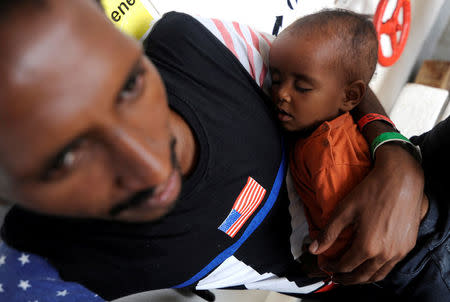 A migrant holds a child on board the MV Aquarius rescue ship, run by SOS Mediterranee organisation and Doctors Without Borders, during a search and rescue (SAR) operation in the Mediterranean Sea, off the Libyan Coast, August 12, 2018. Picture taken August 12, 2018. REUTERS/Guglielmo Mangiapane TPX IMAGES OF THE DAY