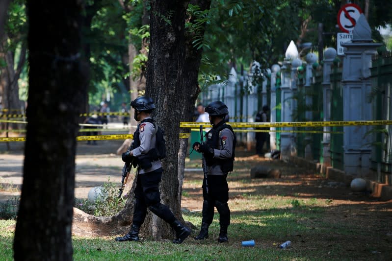 Armed police officers stand guard following a blast at National Monument (Monas) complex in Jakarta