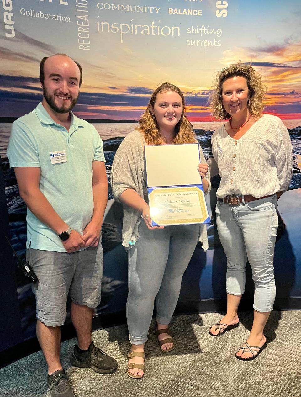 Sean McKenna, left, director of the Seacoast Science Center Marine Science Fellowship program for high school students, and Kate Leavitt, SSC’s Chief Program Officer, right, honored Adrianna George, center, for her achievement in the Marine Science Fellowship Program.