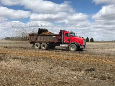 A truck-mounted horizontal spreader applies manure to a field at the NDSU Carrington Research Extension Center.