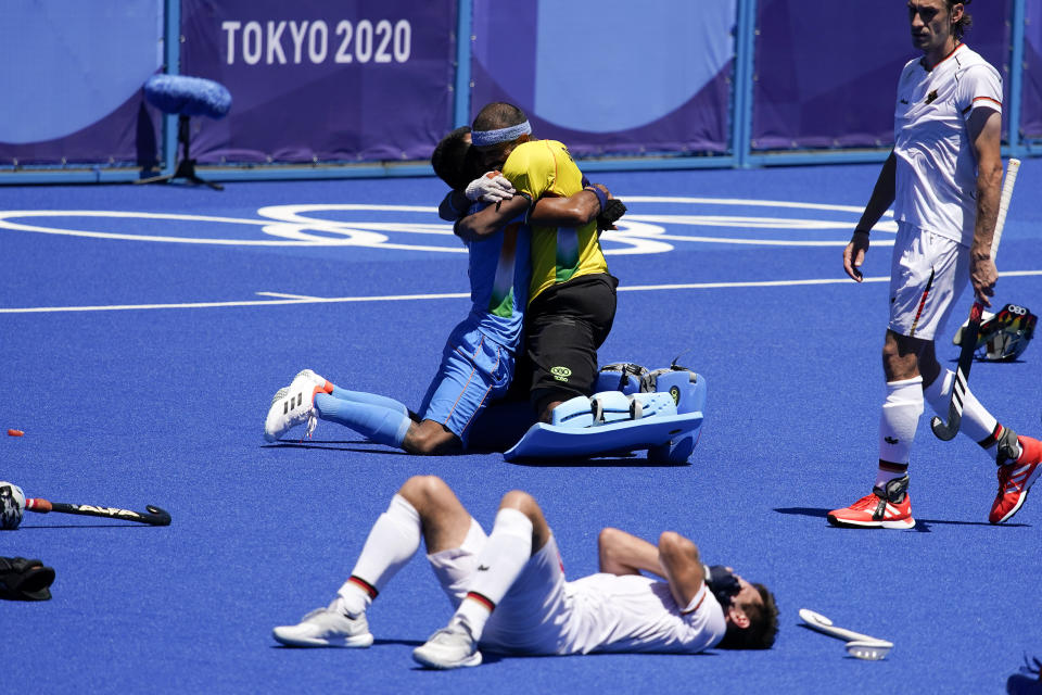 India's Surender Kumar, top left, and India goalkeeper Sreejesh Parattu Raveendran, top right, celebrate while Germany's Lukas Windfeder, bottom, reacts after India won their men's field hockey bronze medal match 5-4 at the 2020 Summer Olympics, Thursday, Aug. 5, 2021, in Tokyo, Japan. (AP Photo/John Locher)