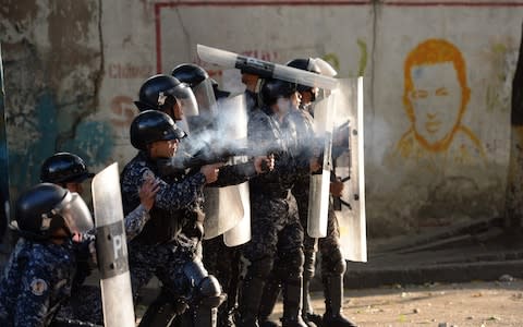 Riot police clash with anti-government demonstrators in the neighborhood of Los Mecedores - Credit: &nbsp;FEDERICO PARRA/&nbsp;AFP