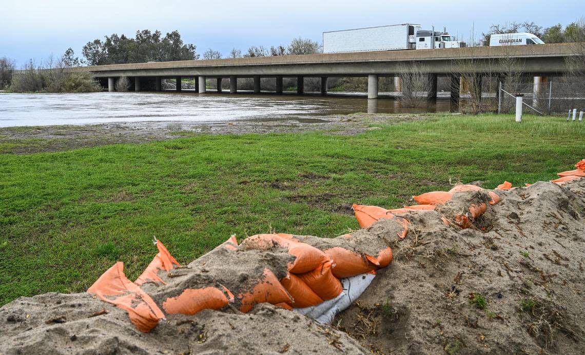 Sandbags are stacked along a berm of sand on the banks of the Kings River near the Riverland RV Park at Highway 99 south of Kingsburg on Tuesday, March 21, 2023. The Kings River has continued to swell along its banks as a cavalcade of storms persists.