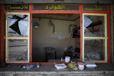 Food containers lie on a windowsill of a shop damaged during fighting in western Mosul, Iraq, April 10, 2017. REUTERS/Andres Martinez Casares