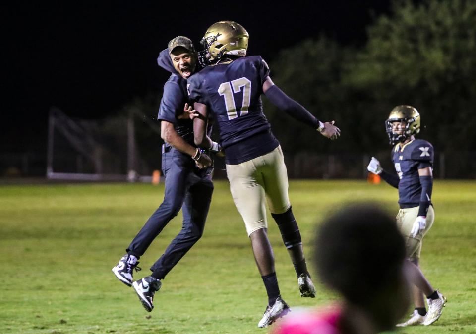 Xavier Prep's Kyle Hill (17) celebrates a defensive touchdown with Head Coach James Dockery during the third quarter of their game at Xavier College Preparatory High School in Palm Desert, Calif., Friday, Sept. 1, 2023.
