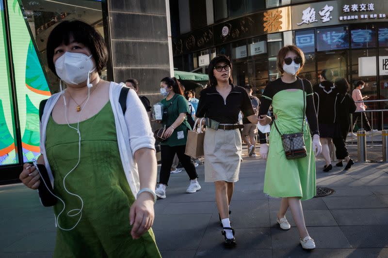 FILE PHOTO: Shoppers walk in a retail district in Beijing