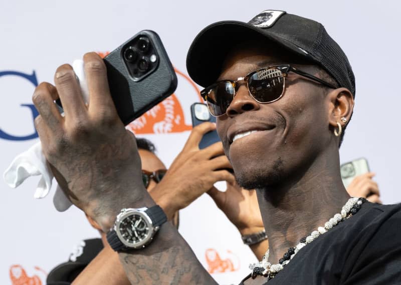 Dennis Schroeder, captain of the German national basketball team, films the team's reception on his cell phone after their sensational World Cup win. Boris Roessler/dpa