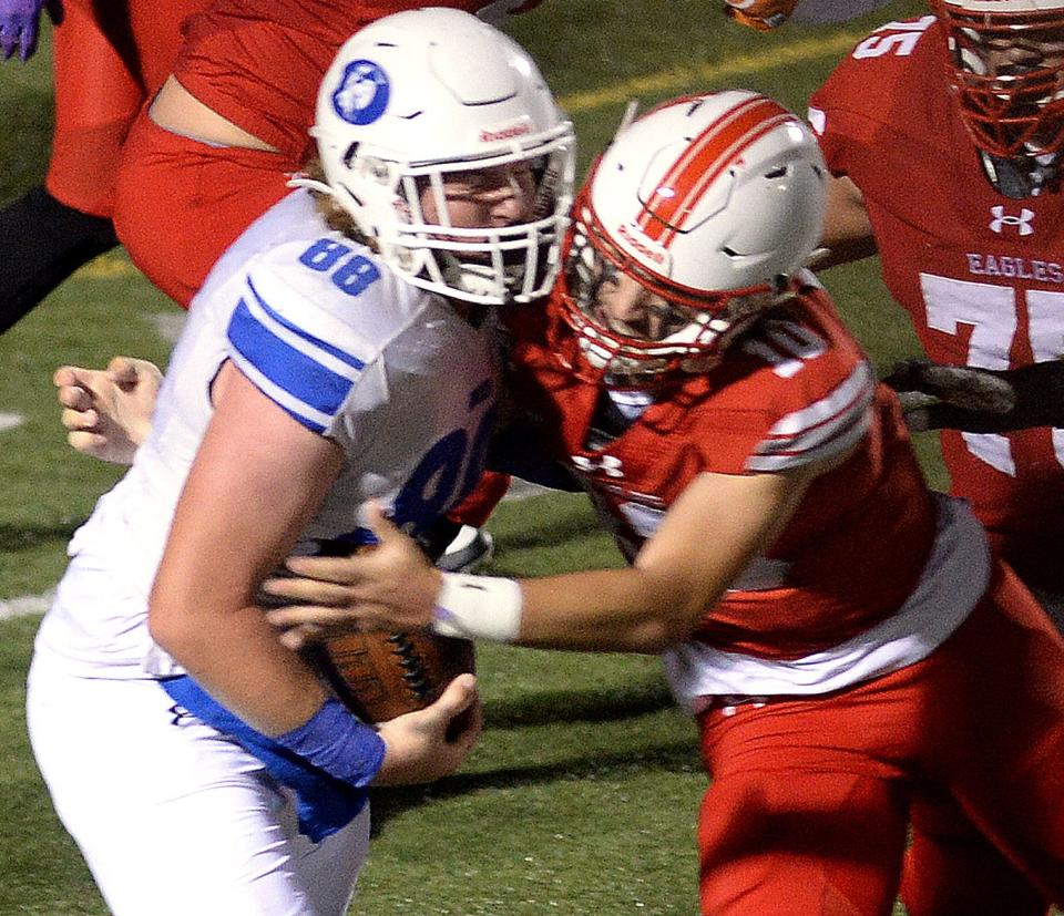 Dover defensive lineman Ryan Perkins (left) rips the ball out of the hands of Smyrna quarterback Jacob Tiberi for a turnover on Friday night. The Senators edged the Eagles 18-14 to move to 7-0 on the season.